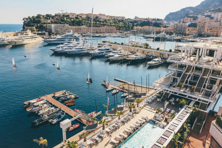Panorama sur le port de la Principauté de Monaco depuis le Yacht Club avec bateaux au premier plan et ville au second plan, le rocher se trouve sur la gauche de l’image.